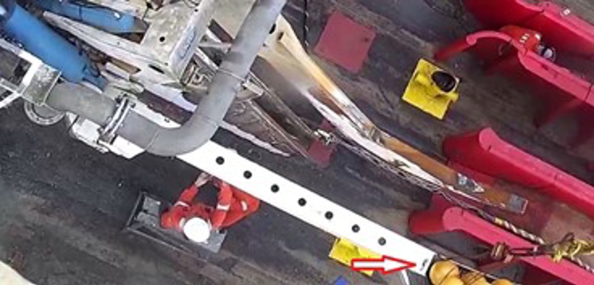 Crew working under the depth skid which is lifted by crane. The red arrow shows the parted hook.