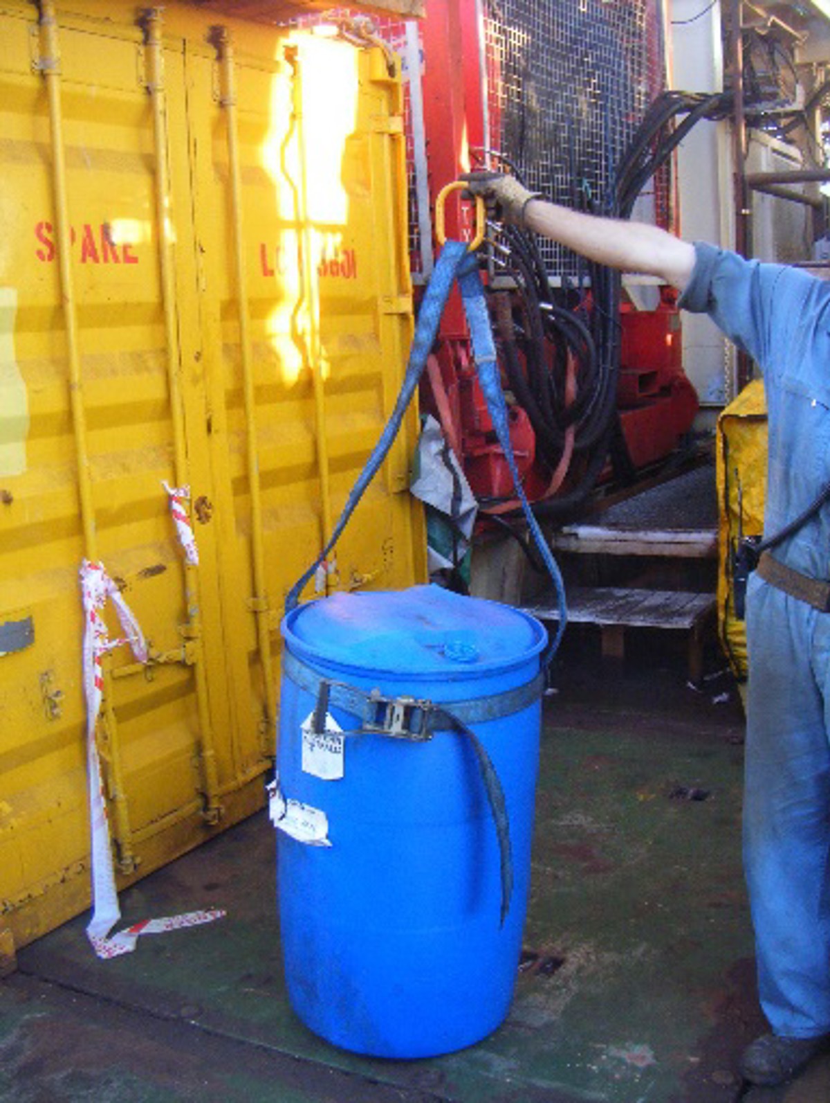 Plastic drum with curved sides with barrel span set lifting strop – poor choice as intended for metal drums