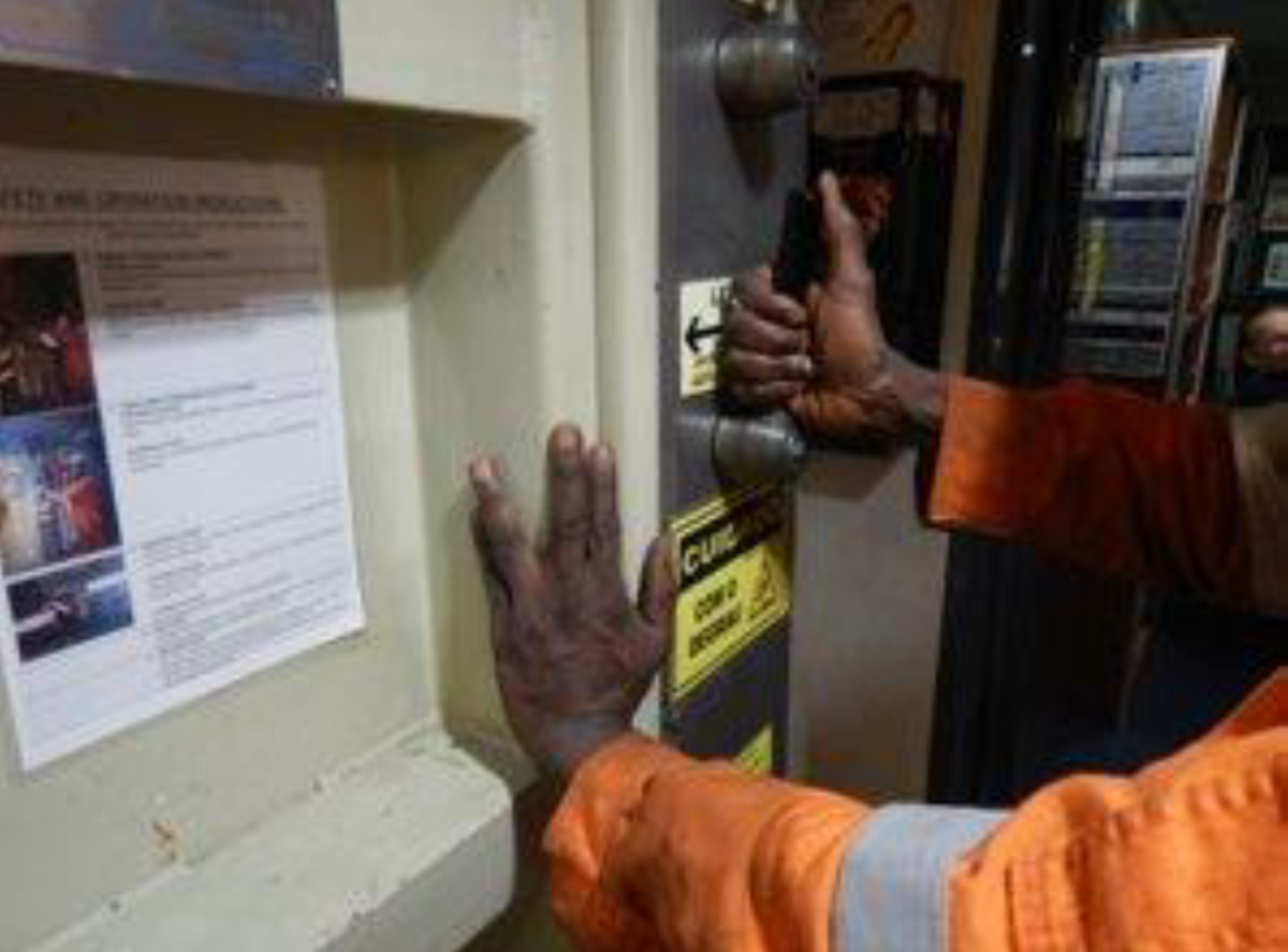 A fitter’s left index finger was pinched between the moving door edge and door frame  causing small abrasions to the index finger